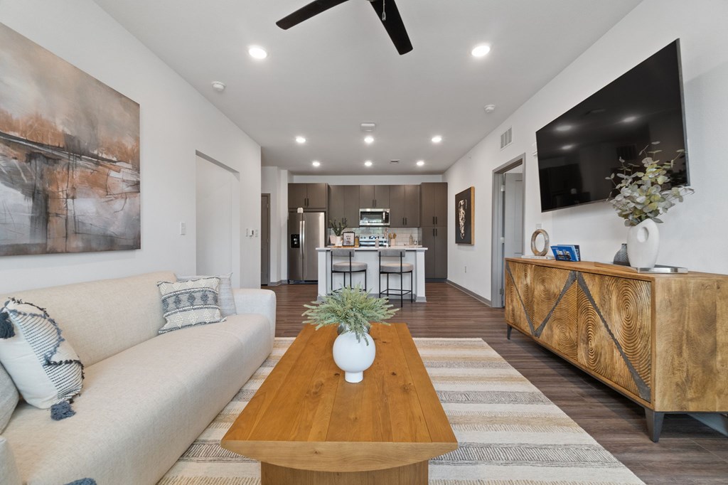 A living room with a couch, a coffee table, and a television.