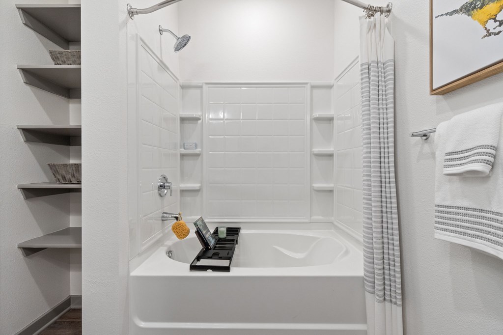 A white bathroom with a white tub and a white shower.