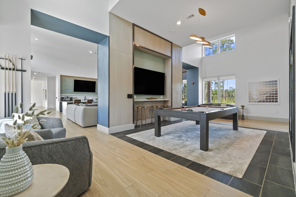 A modern living room with a grey sofa, a wooden coffee table, and a television.