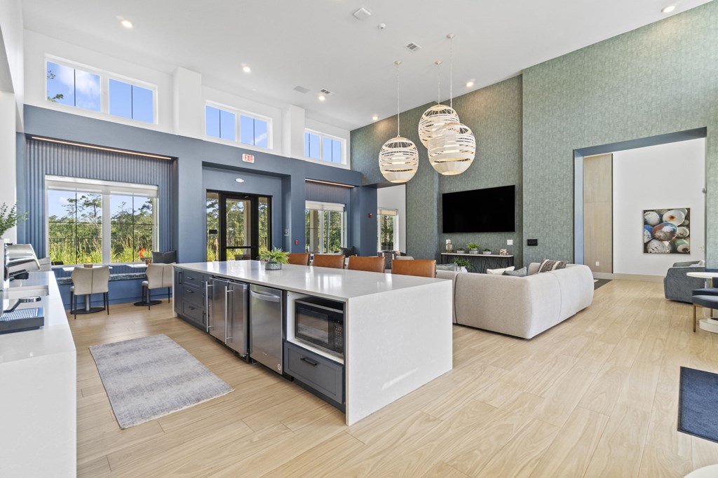 A modern kitchen with a large island and a flat screen TV mounted on the wall.