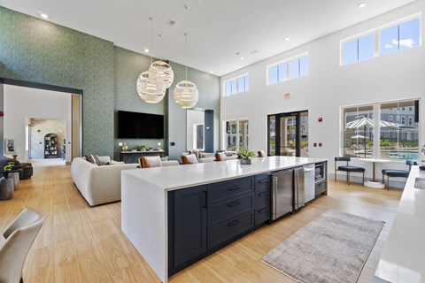 A modern kitchen with a white island and dark cabinets.