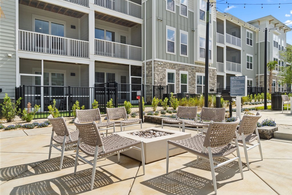 A patio with chairs and a table in front of a building.