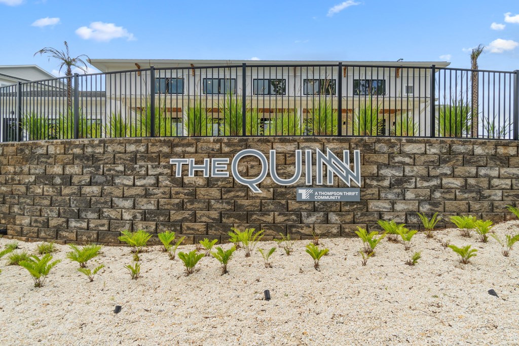 The Quinn sign is on a stone wall.