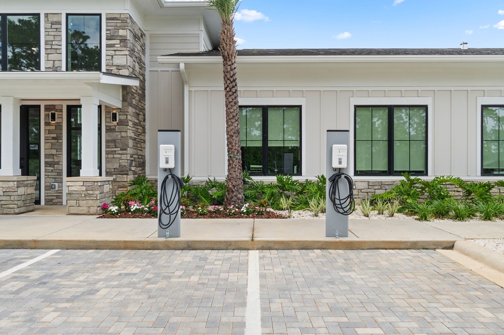Two electric vehicle charging stations are located in front of a modern building.