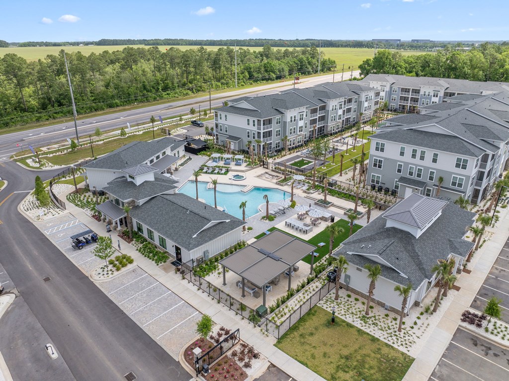 A large apartment complex with a pool and a parking lot.