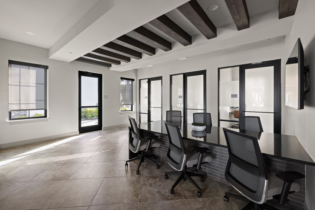 A conference room with black chairs and a long table.