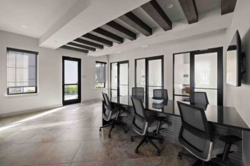 A conference room with black chairs and a long table.