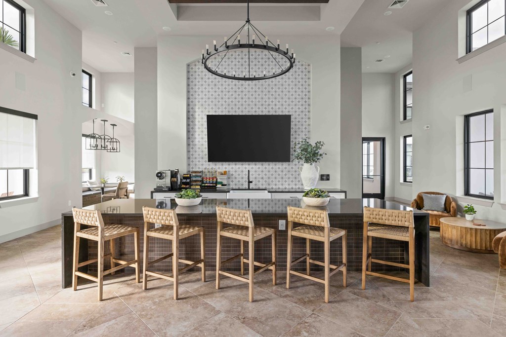 A modern kitchen with a large island and chairs.