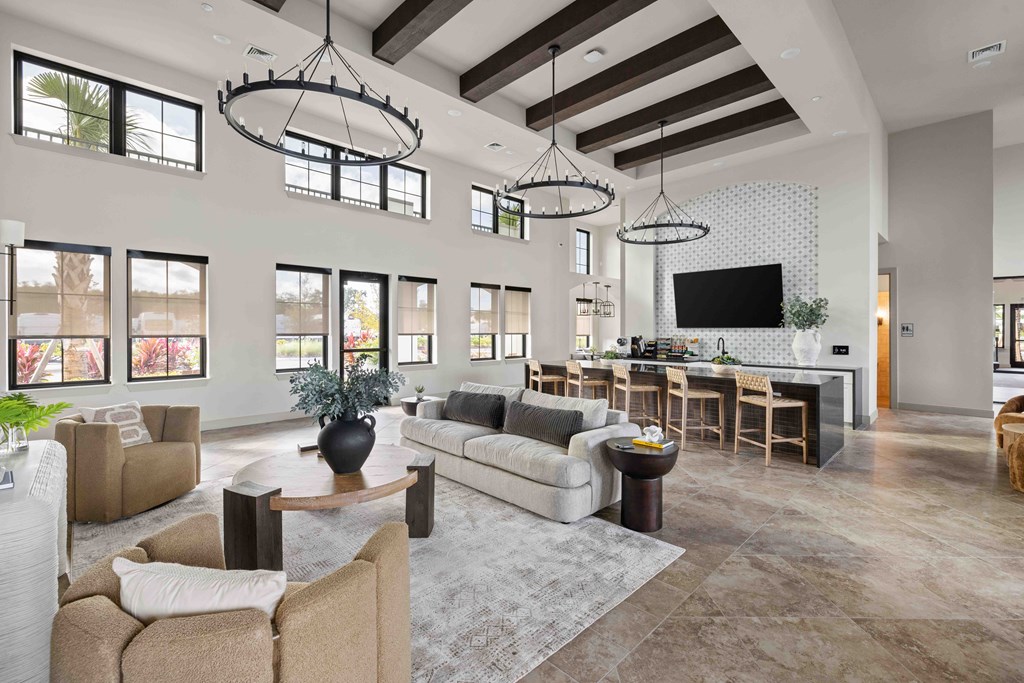A modern living room with a large couch, a coffee table, and a flat-screen TV.