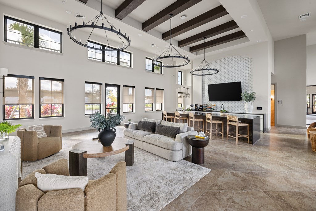 A modern living room with a large couch, a coffee table, and a flat-screen TV.