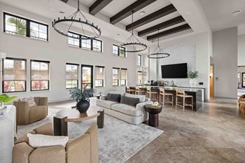 A modern living room with a large couch, a coffee table, and a flat-screen TV.