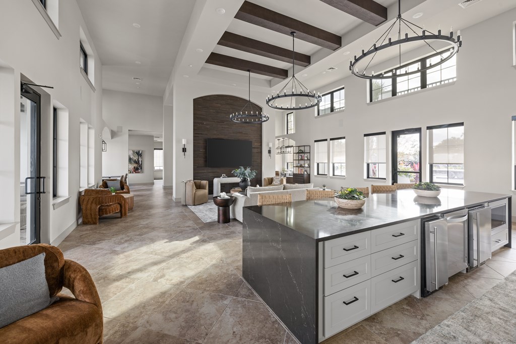 A modern kitchen with a large island and a seating area.