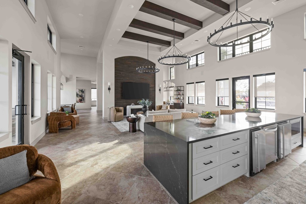 A modern kitchen with a large island and a seating area.
