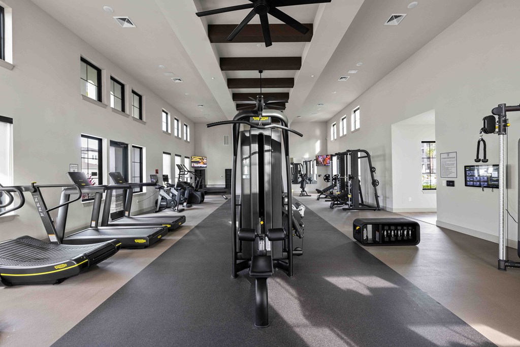 A gym with treadmills, elliptical machines, and other exercise equipment.