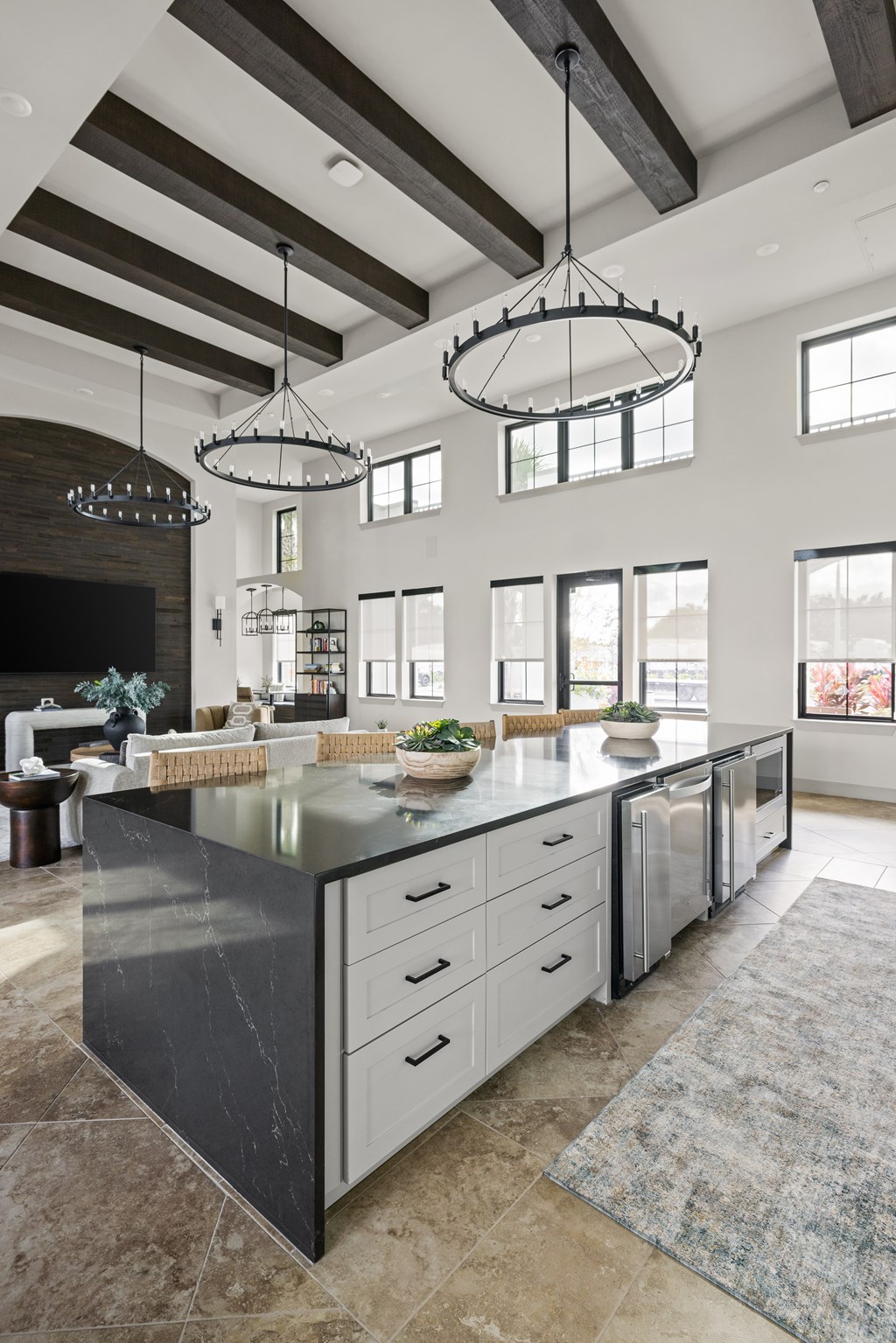 A modern kitchen with a large island and pendant lights.
