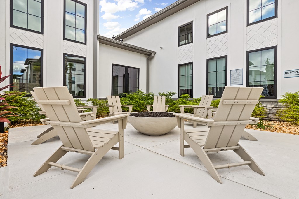 Four chairs are arranged around a table in a courtyard.