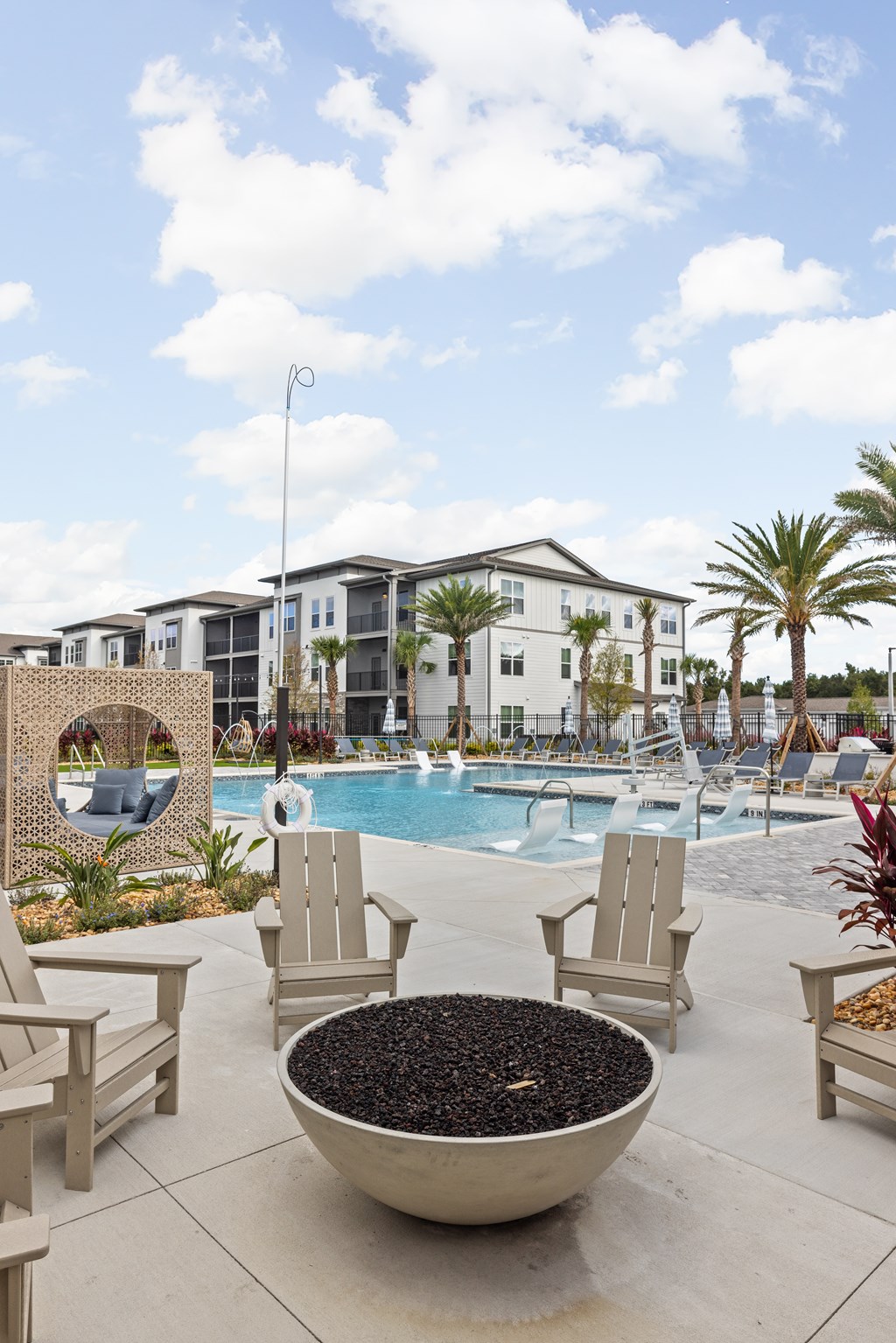 A poolside area with chairs and a bowl of black pebbles.