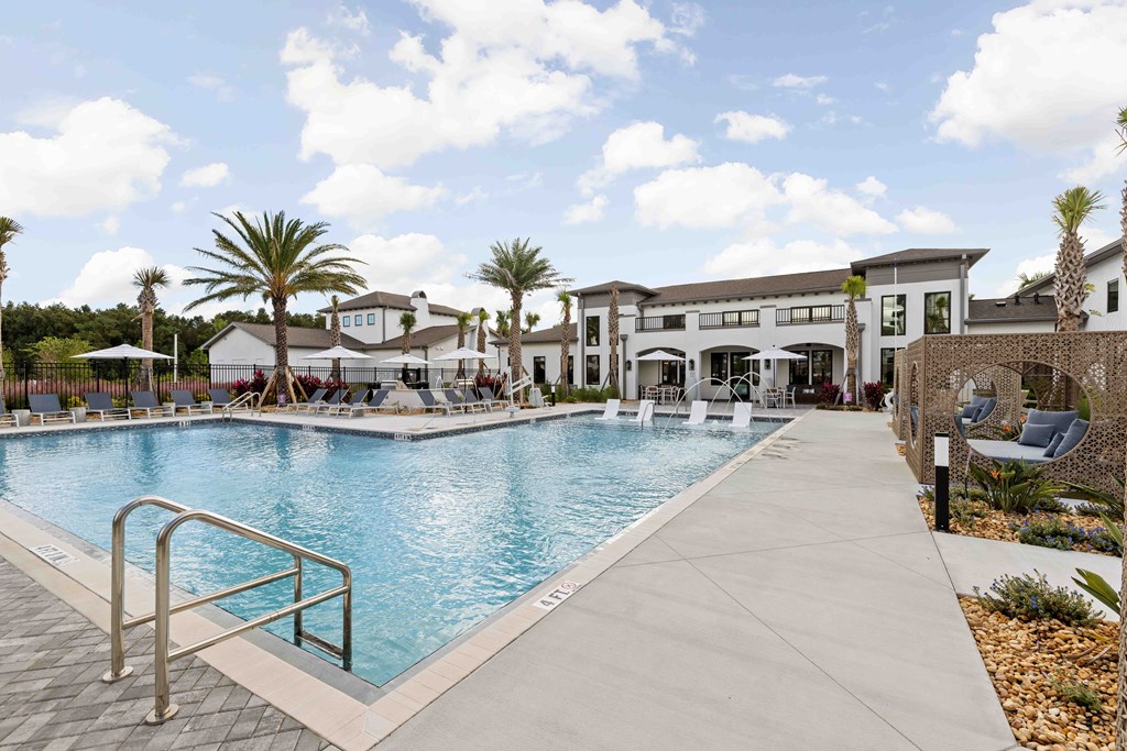 A large swimming pool with a metal ladder and a walkway.
