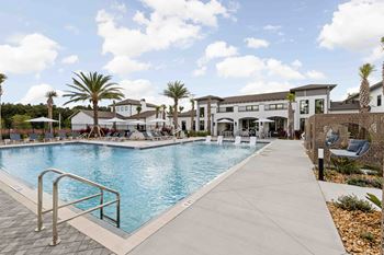 A large swimming pool with a metal ladder and a walkway.