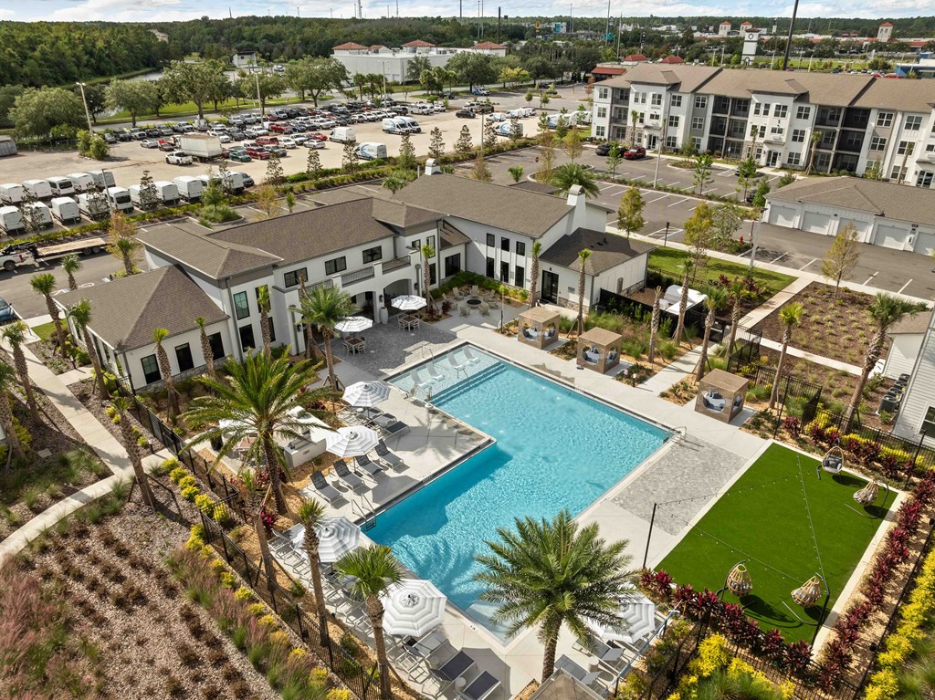 A large building with a pool in the middle of a grassy area.