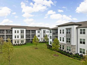 A large white building with a grassy lawn in front.