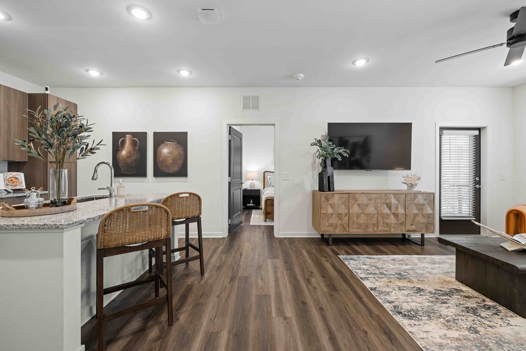 A modern kitchen with wooden floors and furniture.