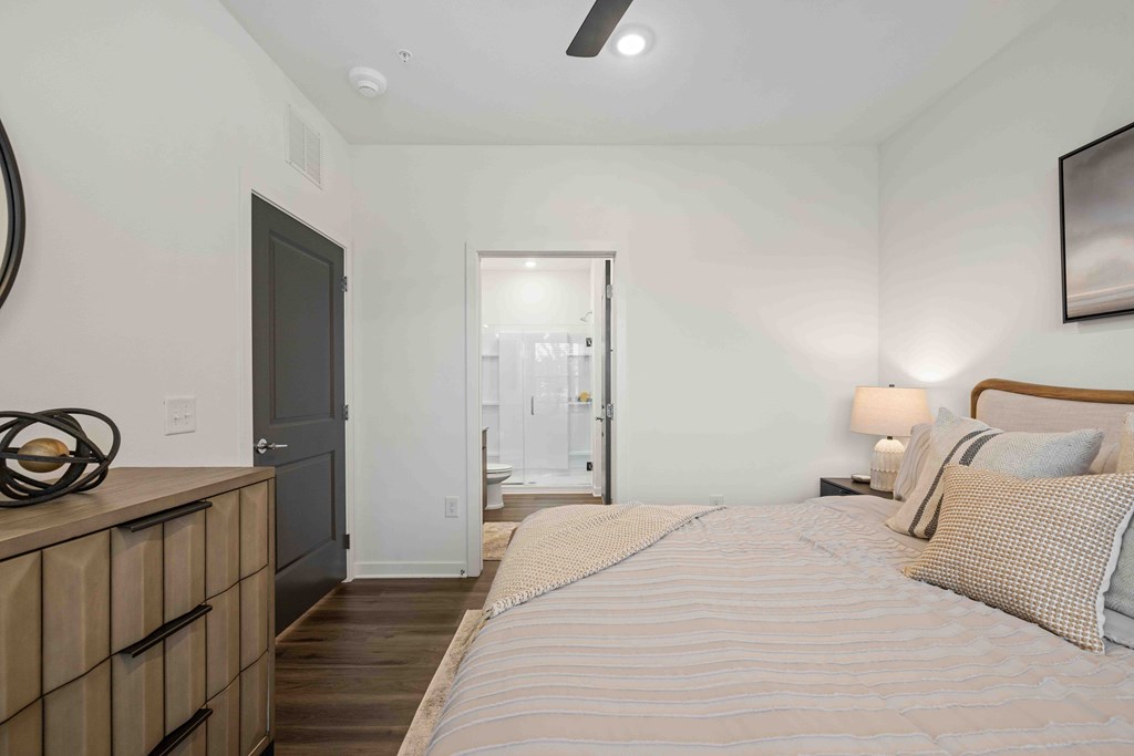 A bedroom with a bed, nightstand, and a dresser.