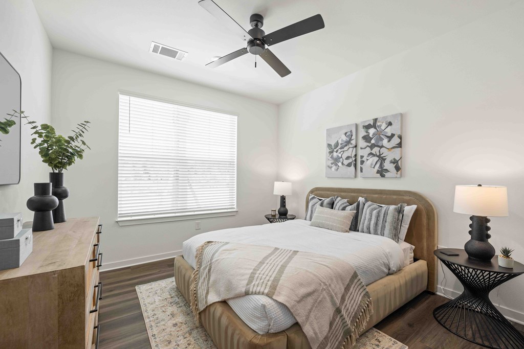 A bedroom with a large bed and a ceiling fan.