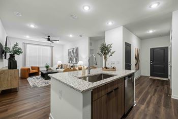 A modern kitchen with a large island and wooden floors.