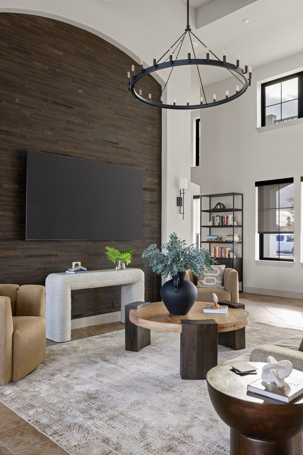 A modern living room with a large flat screen TV mounted on a wooden wall.
