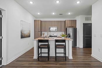 A kitchen with a table and chairs in front of a refrigerator.