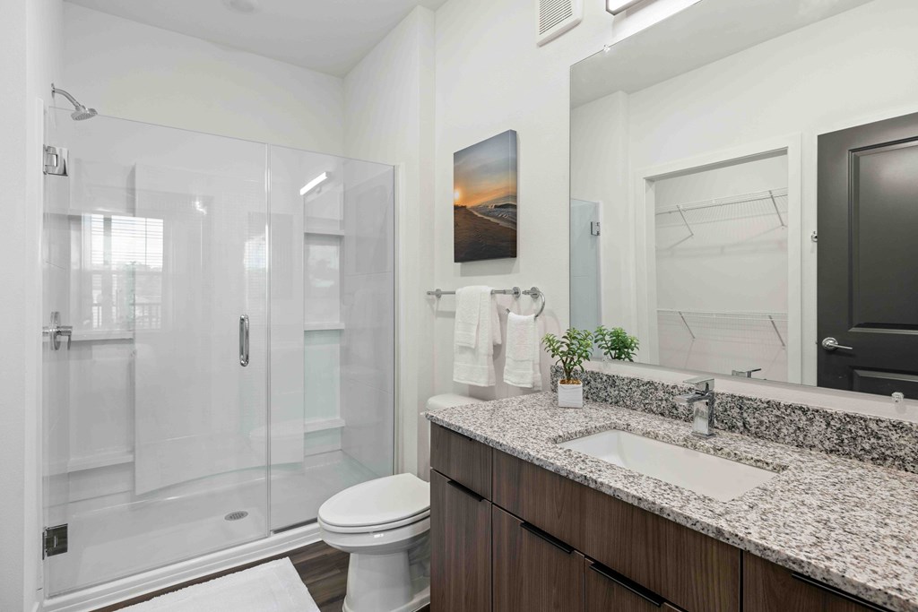 A bathroom with a toilet, sink, and shower.