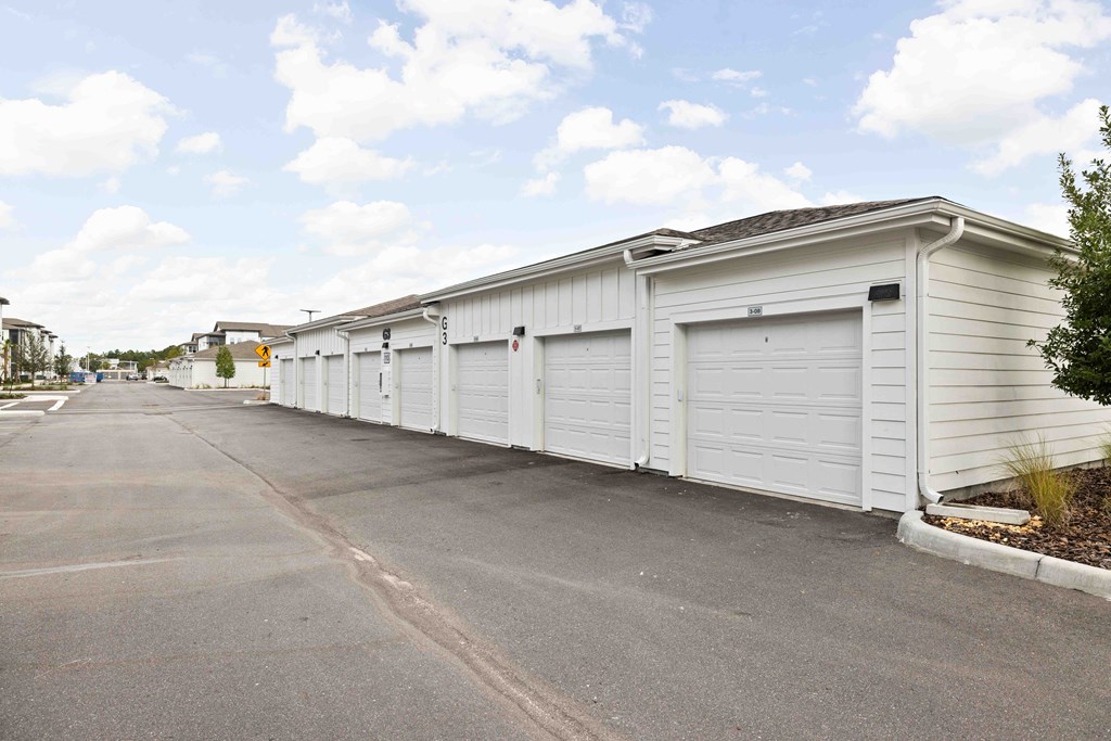 A long white building with a parking lot in front.