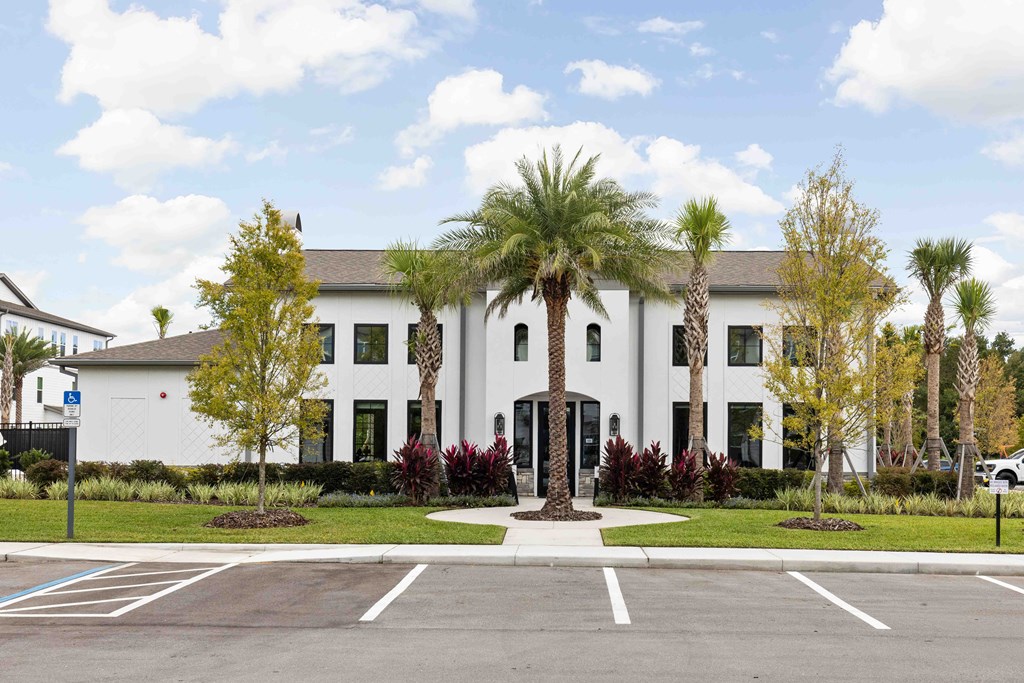 A white building with a parking lot in front.