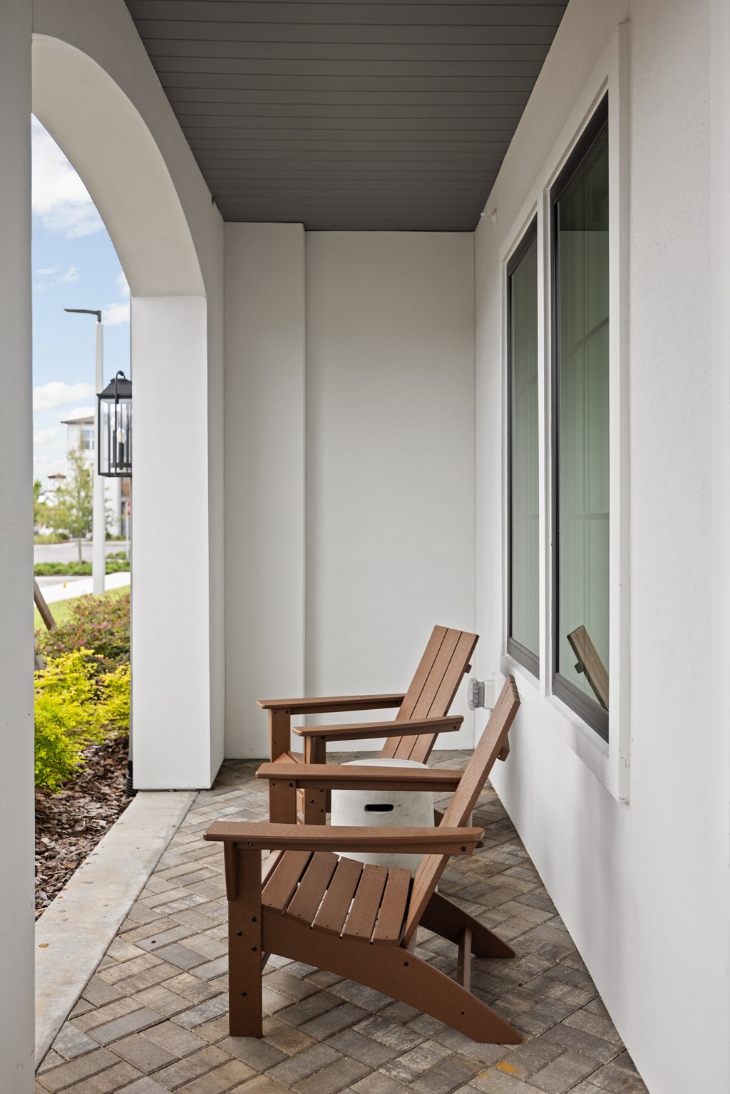 Two chairs and a bench are on a patio.