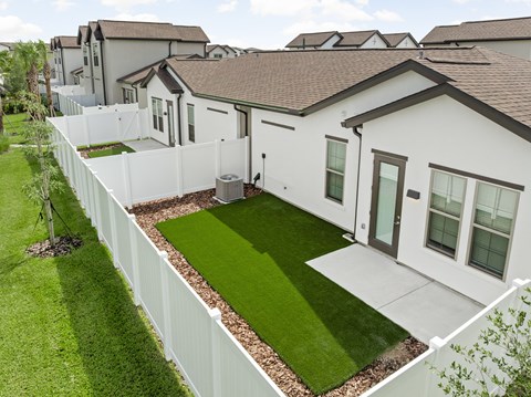 A white house with a green lawn in front.
