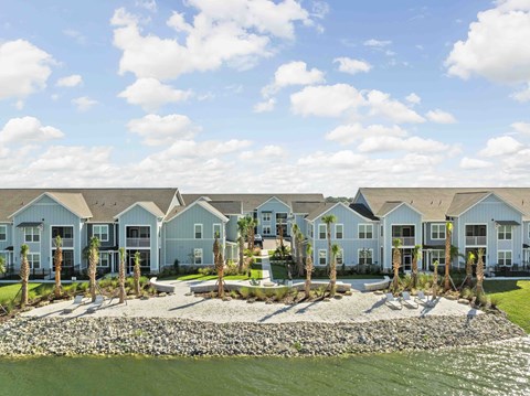 A row of houses with a body of water in front.