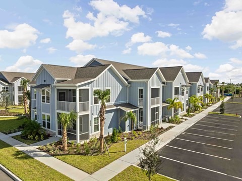 A row of houses with a parking lot in front.