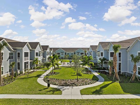 A row of houses with a garden in the foreground.