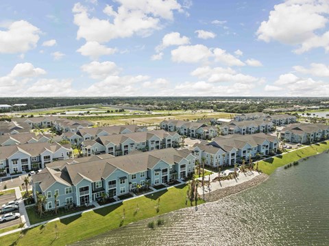 A row of houses with a body of water in front.