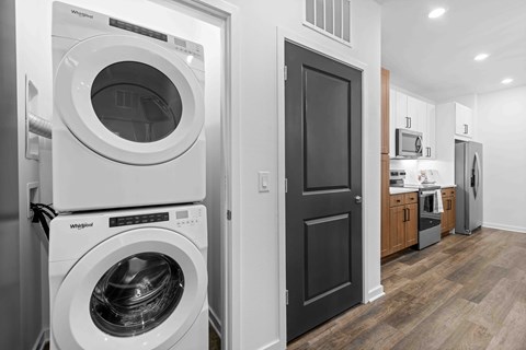 A white Whirlpool washing machine and dryer in a modern laundry room.