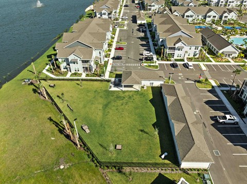 A bird's eye view of a residential area with houses, a road, and a body of water.