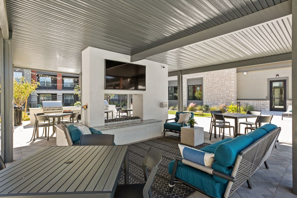 A patio with a table and chairs and a television. at The Maddox Luxury Apartments, Buckeye, AZ, 85326