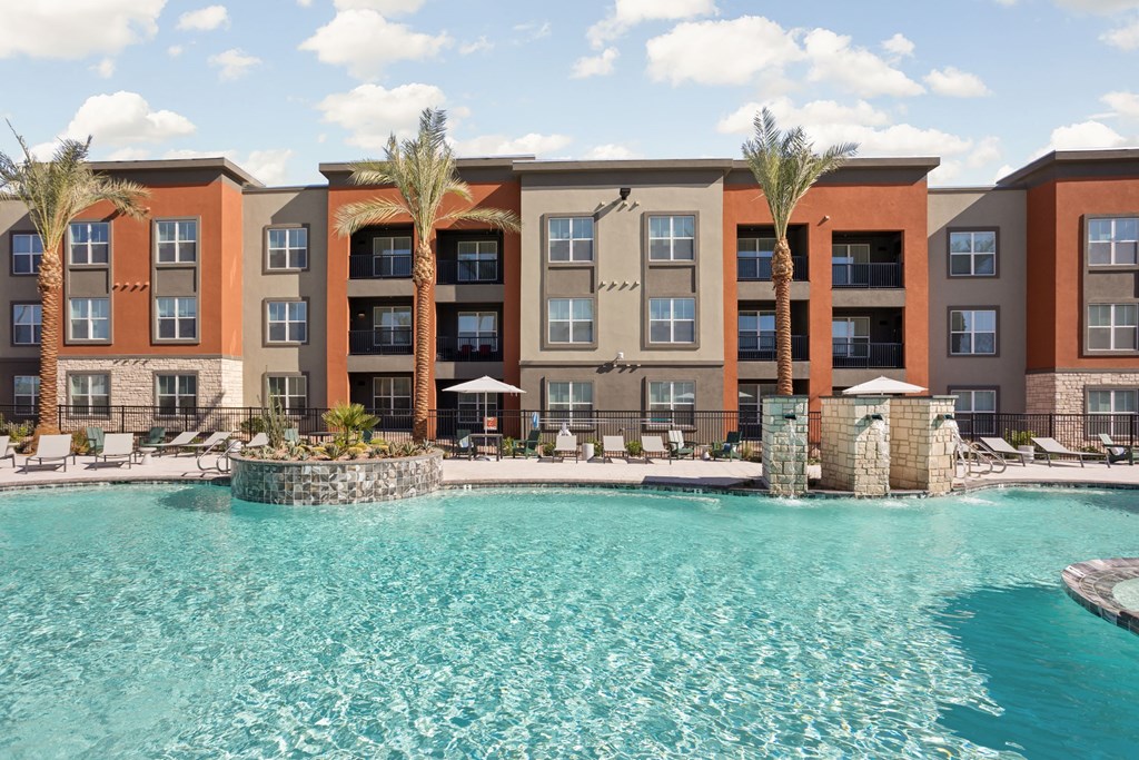 A large swimming pool in front of a multi-story apartment building at The Maddox Luxury Apartments, Buckeye, AZ, 85326