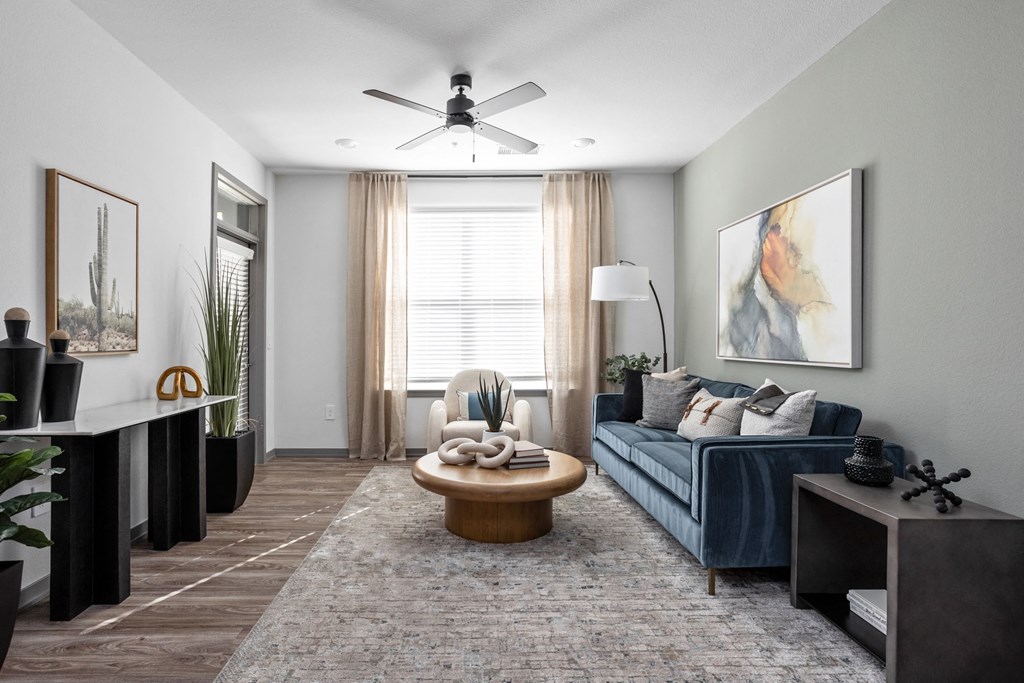 A living room with a blue couch and a coffee table. at The Maddox Luxury Apartments, Buckeye, AZ, 85326