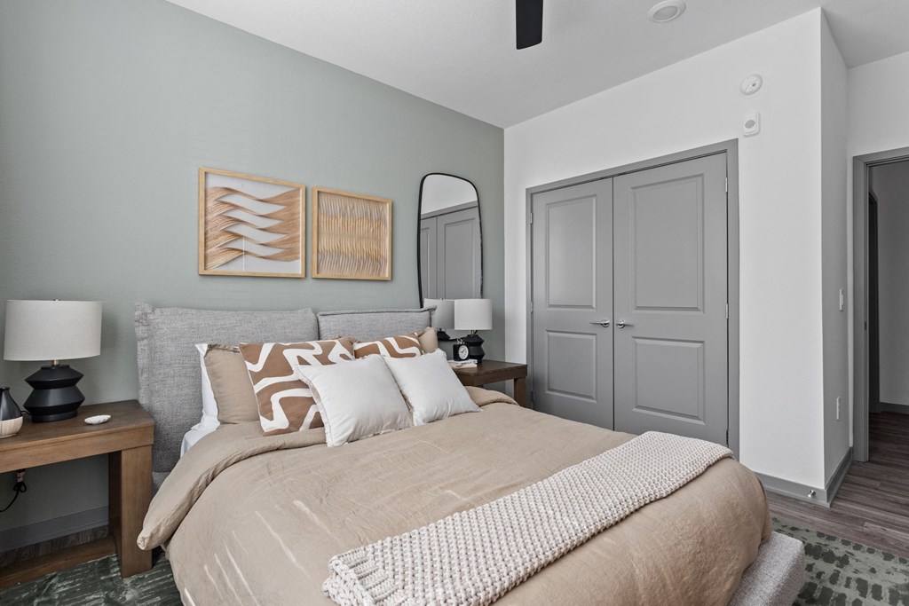 A bedroom with a bed, nightstand, and a painting on the wall. at The Maddox Luxury Apartments, Buckeye, AZ, 85326