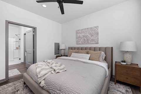 A bedroom with a large bed and a ceiling fan.
