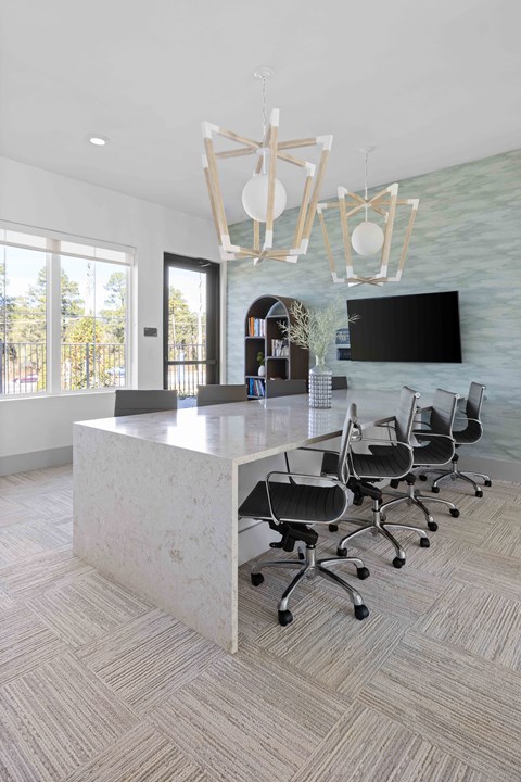 A modern office space with a large desk and chairs.