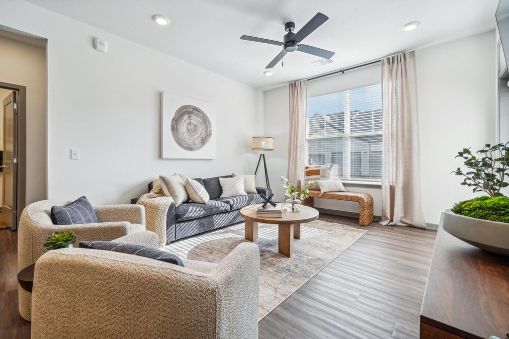 a living room with furniture and a ceiling fan at Premier at West Park Luxury Apartment Homes, Greeley