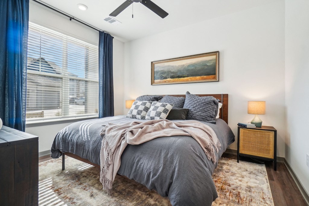 a bedroom with a bed and a large window at Premier at West Park Luxury Apartment Homes, Colorado